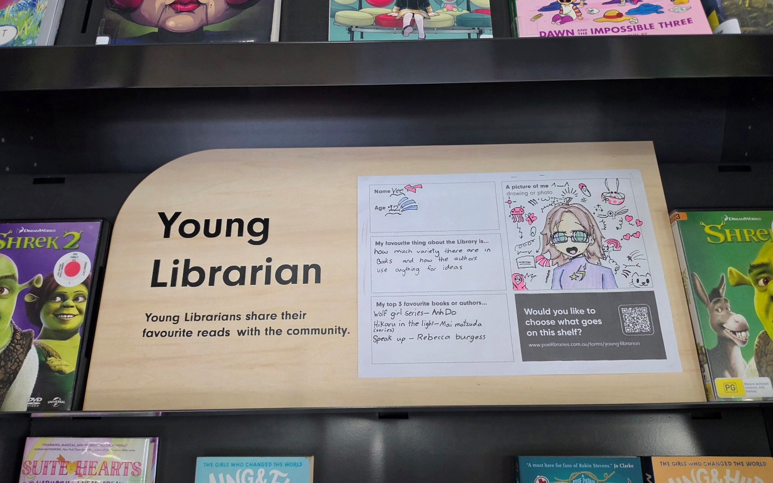 Picture of a 'Young Librarian' sign sitting on a shelf of books in the library