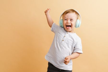 child wearing headphones with arm raised as dancing