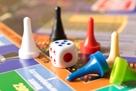 stack of boxed board games and card games, with dice