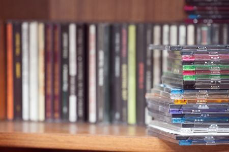 stack of colourful CDs in foreground against row of CDs in background